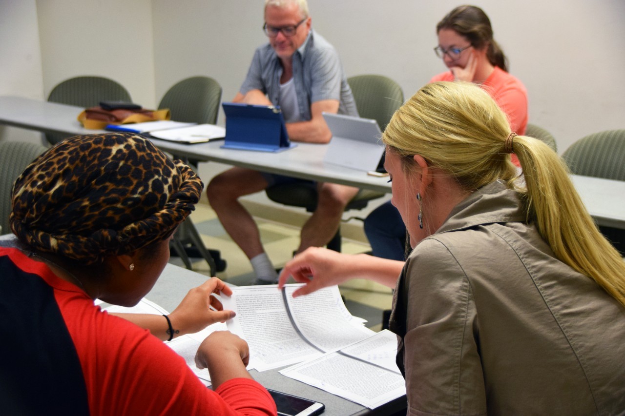 Two graduate students review a printed document.